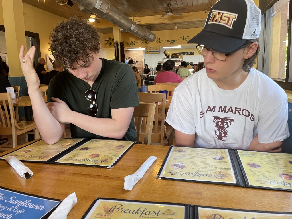 The boys searching the menu at Sunflower Bakery and Cafe in Galveston